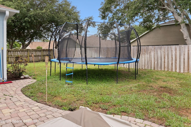 view of yard featuring a fenced backyard and a trampoline