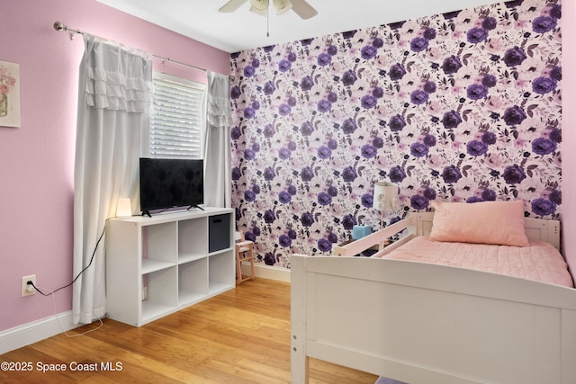 bedroom featuring light wood-type flooring, a ceiling fan, and baseboards