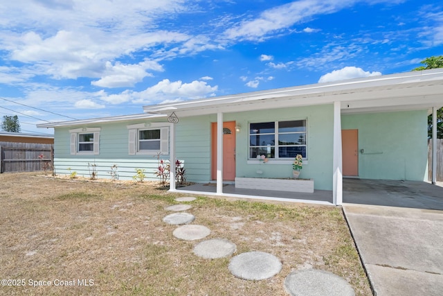 1380 Fiddler Ave, Merritt Island, FL 32952 - view of front facade featuring concrete driveway, fence, covered porch, and an attached carport