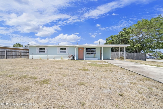 1380 Fiddler Ave, Merritt Island, FL 32952 - ranch-style house featuring concrete driveway, fence, a front yard, and an attached carport