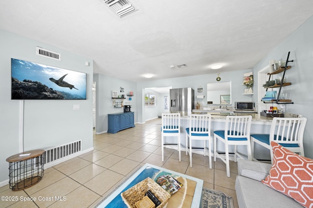 1380 Fiddler Ave, Merritt Island, FL 32952 - living area with light tile patterned flooring, baseboards, visible vents, and a textured ceiling