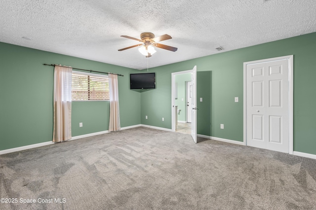 unfurnished bedroom featuring carpet floors, a textured ceiling, and baseboards
