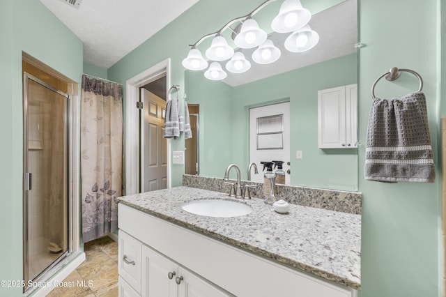 bathroom featuring a tile shower, vanity, and tile patterned flooring