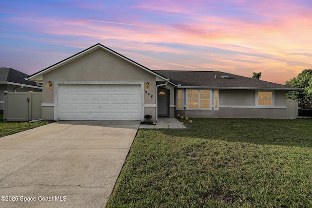 single story home with a lawn, an attached garage, driveway, and stucco siding
