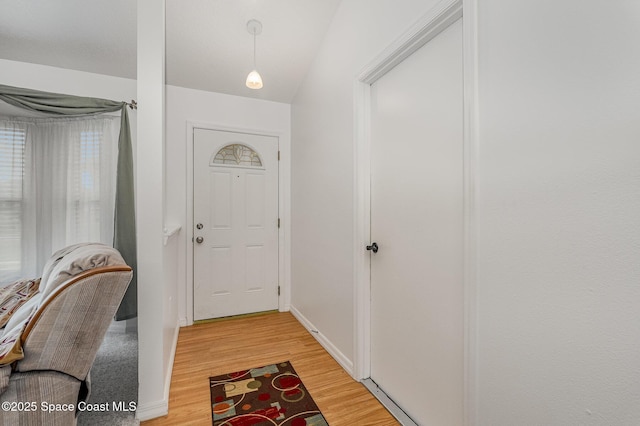 entryway with baseboards and light wood finished floors