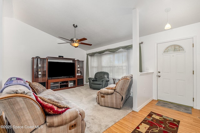 living area featuring baseboards, ceiling fan, wood finished floors, and lofted ceiling