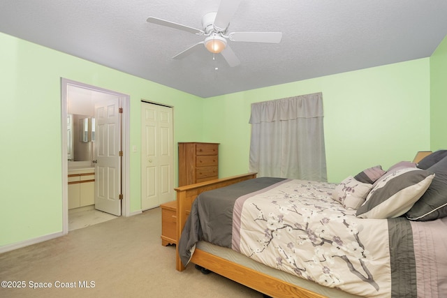 bedroom featuring a closet, ceiling fan, a textured ceiling, carpet, and ensuite bath