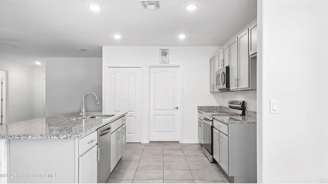 6878 Hartford Rd, Cocoa, FL 32927 - kitchen with stainless steel appliances, a sink, light tile patterned floors, recessed lighting, and a kitchen island with sink