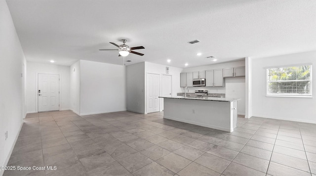 6878 Hartford Rd, Cocoa, FL 32927 - kitchen with stainless steel appliances, gray cabinetry, a sink, light tile patterned floors, and open floor plan
