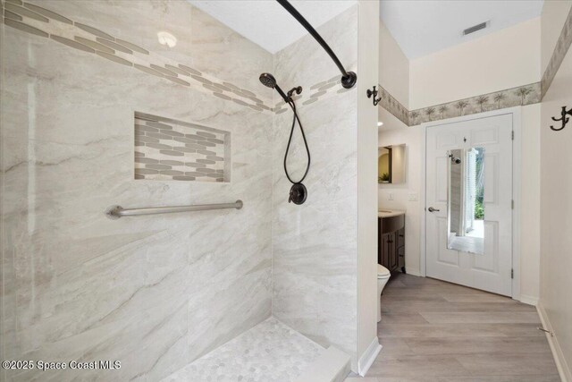 1019 Worthington Spring Dr, Melbourne, FL 32940 - bathroom featuring vanity, a tile shower, toilet, and wood finished floors