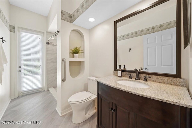 1019 Worthington Spring Dr, Melbourne, FL 32940 - bathroom featuring toilet, baseboards, tiled shower, wood finished floors, and vanity