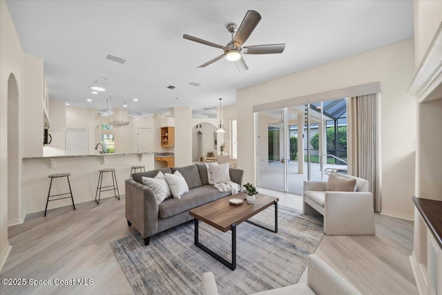 1019 Worthington Spring Dr, Melbourne, FL 32940 - living area featuring arched walkways, light wood-style flooring, ceiling fan, baseboards, and recessed lighting