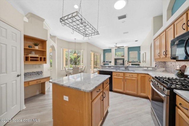 1019 Worthington Spring Dr, Melbourne, FL 32940 - kitchen featuring black appliances, a sink, arched walkways, a kitchen island, and a peninsula