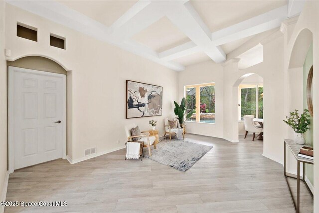 1019 Worthington Spring Dr, Melbourne, FL 32940 - living area with beamed ceiling, arched walkways, coffered ceiling, light wood-style flooring, and baseboards