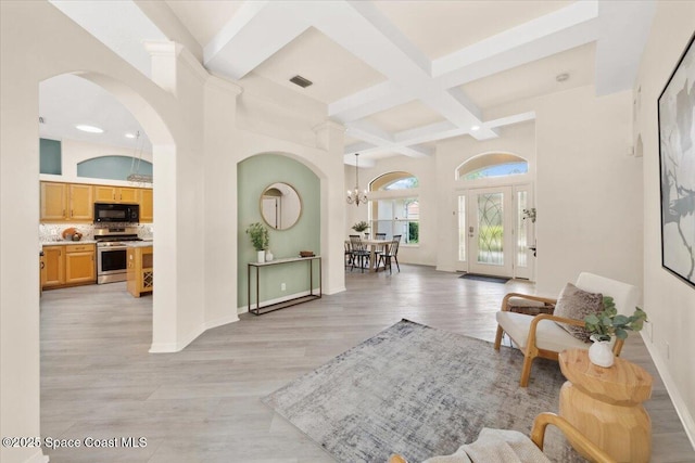 1019 Worthington Spring Dr, Melbourne, FL 32940 - entrance foyer with arched walkways, beam ceiling, coffered ceiling, a chandelier, and light wood-style floors