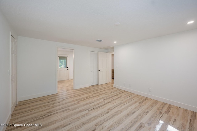 unfurnished room with baseboards, recessed lighting, light wood-style flooring, and visible vents