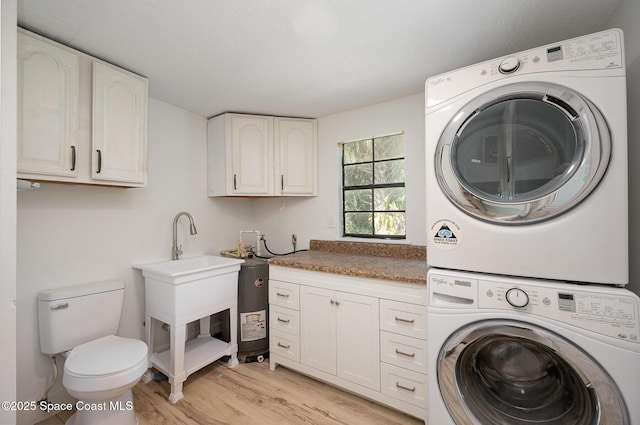 washroom featuring laundry area, light wood finished floors, and stacked washer and clothes dryer