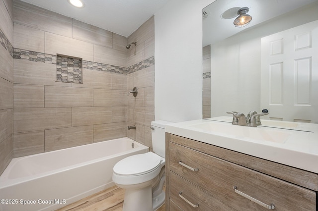 bathroom with vanity, shower / bathtub combination, toilet, and wood finished floors