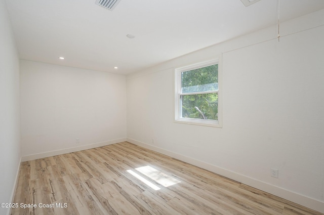 spare room featuring attic access, visible vents, wood finished floors, baseboards, and recessed lighting