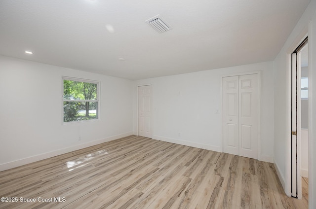 spare room featuring recessed lighting, baseboards, visible vents, and light wood-type flooring