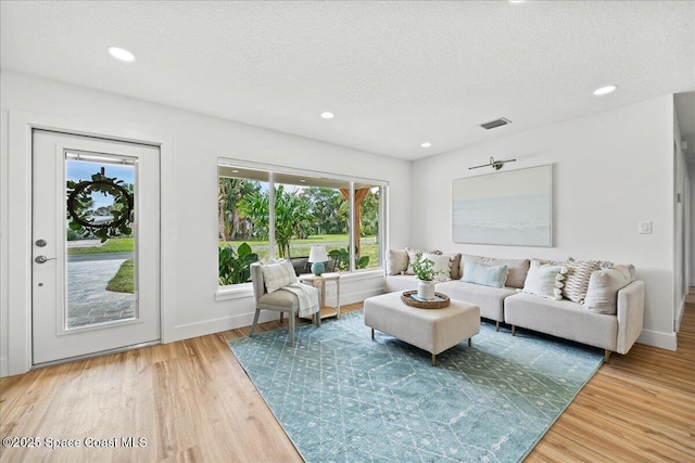 2059 Barracuda Ave, Melbourne Beach, FL 32951 - living area featuring a healthy amount of sunlight, a textured ceiling, recessed lighting, and wood finished floors