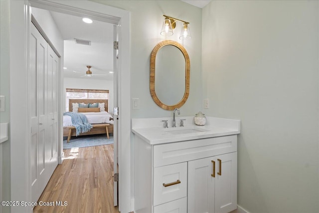 2059 Barracuda Ave, Melbourne Beach, FL 32951 - bathroom featuring ceiling fan, visible vents, wood finished floors, vanity, and connected bathroom