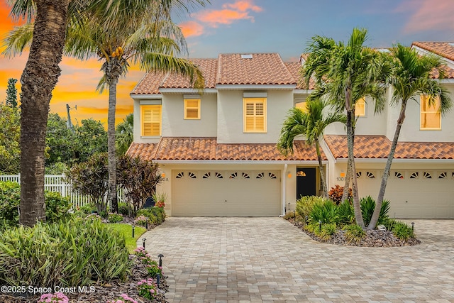 mediterranean / spanish home featuring stucco siding and a tiled roof