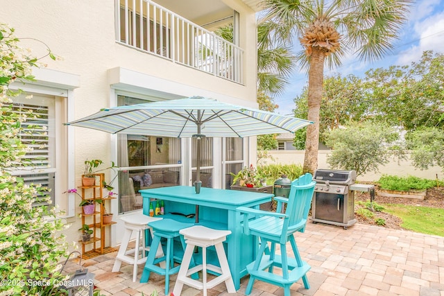 view of patio / terrace with outdoor dining area, a balcony, and a grill