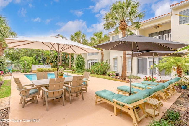 view of patio / terrace featuring a ceiling fan, outdoor dining space, and an outdoor pool