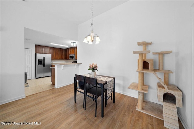 4016 Meander Pl Unit 207, Rockledge, FL 32955 - dining area with a chandelier, light wood finished floors, and baseboards