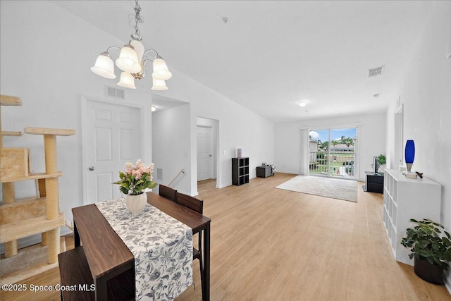 4016 Meander Pl Unit 207, Rockledge, FL 32955 - dining area featuring a chandelier, vaulted ceiling, light wood-style flooring, and baseboards