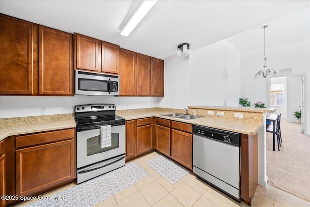 4016 Meander Pl Unit 207, Rockledge, FL 32955 - kitchen featuring appliances with stainless steel finishes, a sink, a peninsula, a chandelier, and light tile patterned floors