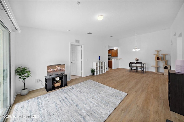 4016 Meander Pl Unit 207, Rockledge, FL 32955 - living area with a chandelier, light wood-type flooring, and baseboards