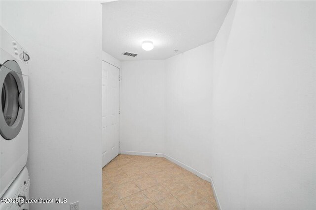 4016 Meander Pl Unit 207, Rockledge, FL 32955 - washroom with stacked washing machine and dryer and baseboards