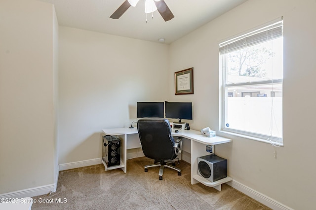 carpeted office featuring baseboards and ceiling fan