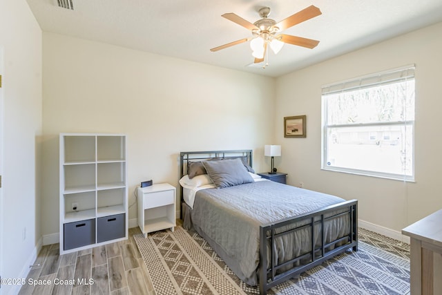 bedroom featuring a ceiling fan, baseboards, visible vents, and light wood-type flooring