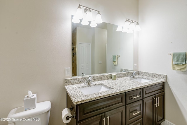 bathroom featuring a sink, toilet, and double vanity