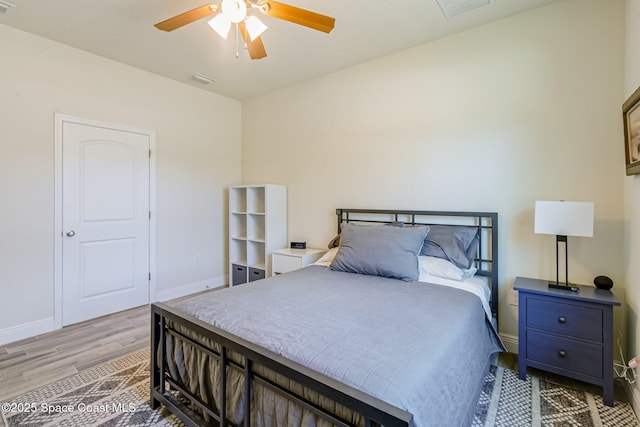 bedroom featuring ceiling fan, baseboards, visible vents, and light wood-style flooring