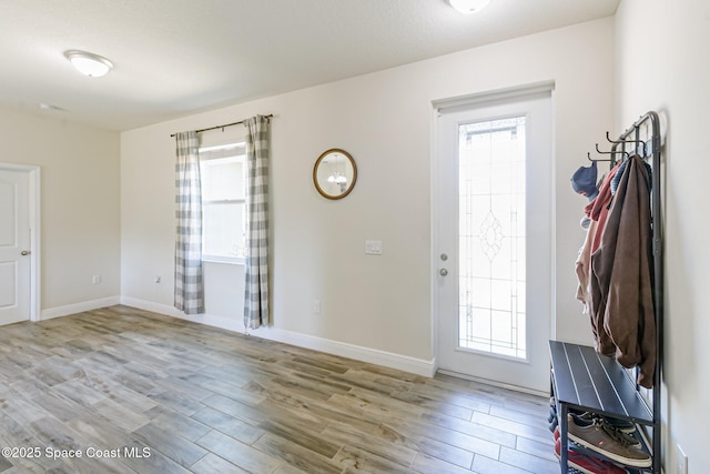 interior space featuring light wood-style floors, baseboards, and a wealth of natural light