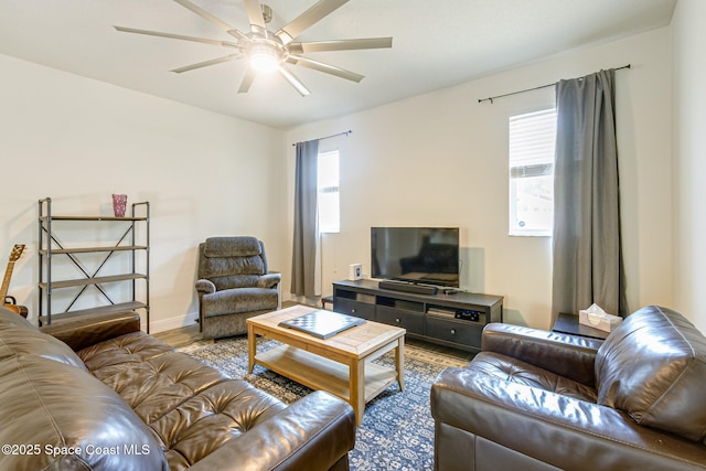 living area featuring baseboards, ceiling fan, and wood finished floors