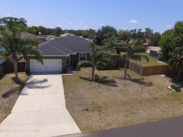 ranch-style home featuring a garage, fence, driveway, and a front yard