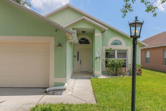 2801 Saint James Ln, Melbourne, FL 32935 - entrance to property featuring stucco siding, a garage, a yard, and driveway