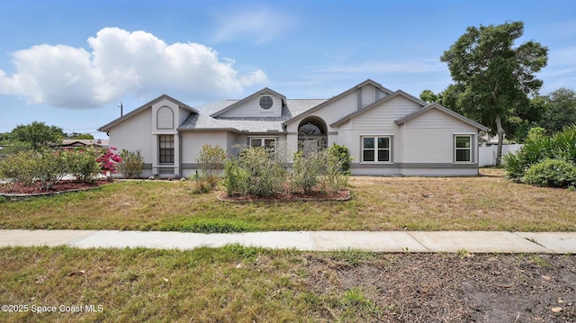 2615 Slash Pine Ct, Titusville, FL 32780 - ranch-style house featuring roof with shingles, a front yard, and stucco siding