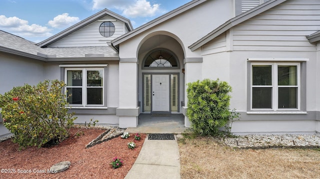 2615 Slash Pine Ct, Titusville, FL 32780 - view of exterior entry featuring a shingled roof and stucco siding
