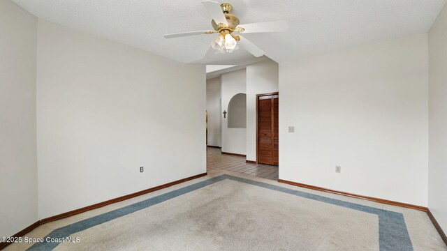 2615 Slash Pine Ct, Titusville, FL 32780 - empty room featuring arched walkways, a ceiling fan, baseboards, and carpet