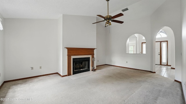 2615 Slash Pine Ct, Titusville, FL 32780 - unfurnished living room featuring ceiling fan, light colored carpet, a fireplace with flush hearth, visible vents, and high vaulted ceiling