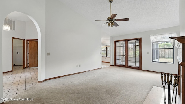 2615 Slash Pine Ct, Titusville, FL 32780 - unfurnished living room featuring carpet flooring, arched walkways, a ceiling fan, and plenty of natural light
