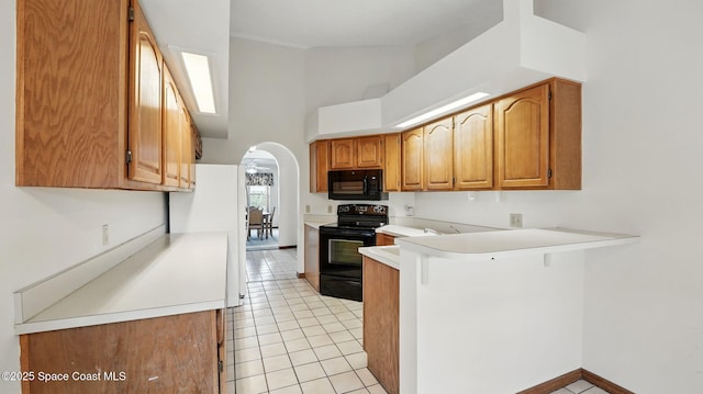 2615 Slash Pine Ct, Titusville, FL 32780 - kitchen featuring arched walkways, light countertops, black appliances, a peninsula, and a high ceiling
