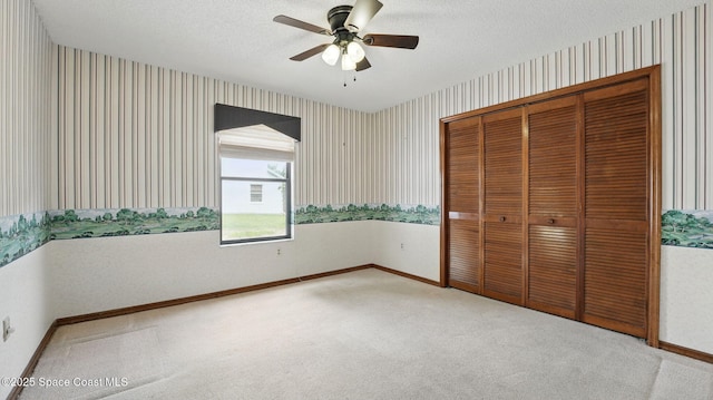 2615 Slash Pine Ct, Titusville, FL 32780 - unfurnished bedroom with a closet, baseboards, wallpapered walls, a textured ceiling, and carpet