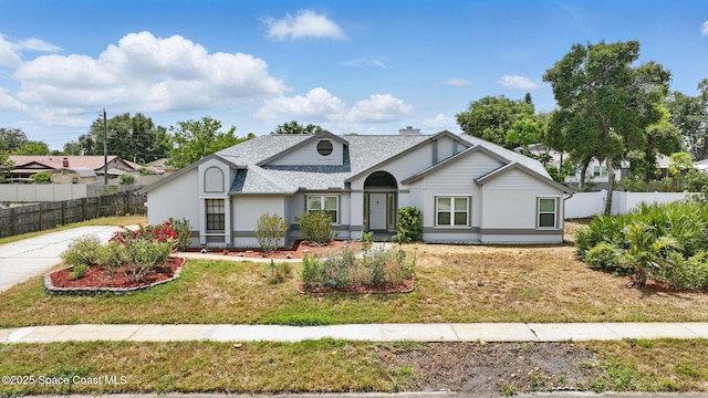 2615 Slash Pine Ct, Titusville, FL 32780 - view of front of home featuring fence, a shingled roof, a front yard, and stucco siding